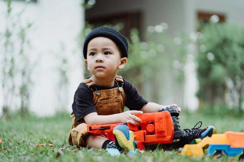 Anak bermain ceria di luar ruangan untuk mendukung cara mengatur waktu belajar dan bermain anak.