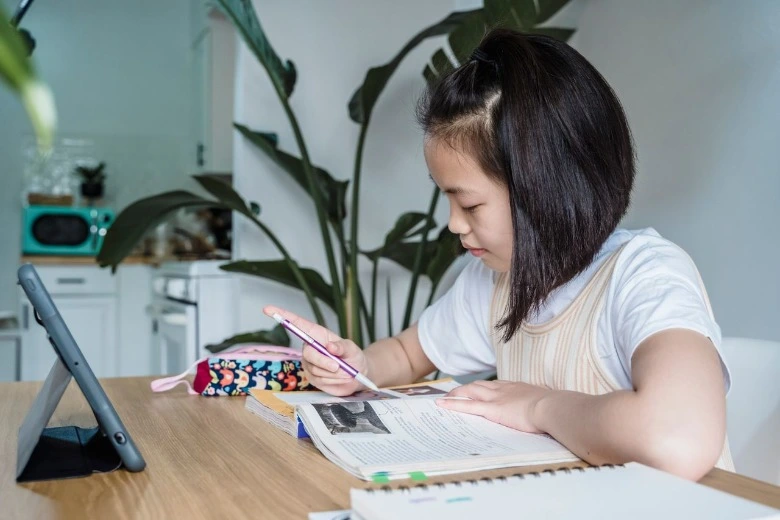 Anak yang sedang fokus belajar sebagai ilustrasi cara membuat jadwal belajar anak di rumah.