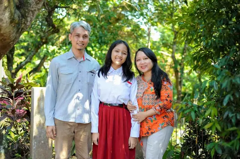 Orang tua berdiskusi santai dengan anak untuk memberikan motivasi selama masa adaptasi anak masuk smp.