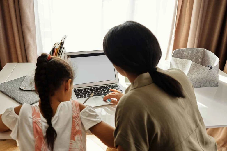Ibu membantu anak perempuan mengerjakan tugas sekolah sebagai cara mendampingi anak menghadapi kurikulum baru.