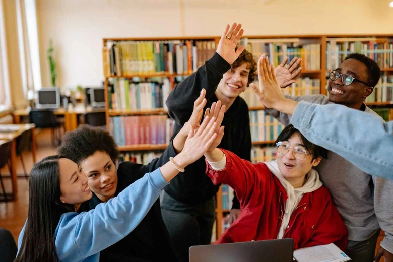 Guru dan siswa melakukan interaksi positif di kelas, mencerminkan lingkungan belajar joyful dalam kurikulum tahun ajaran 2026 2027.