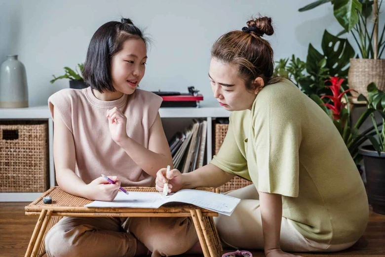 Orang tua mendampingi anak mengerjakan tugas sekolah untuk mengatasi learning loss anak setelah libur panjang.