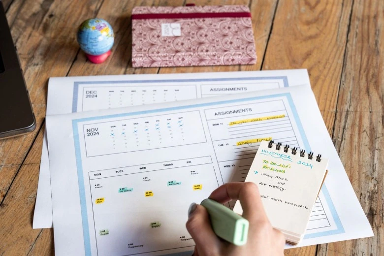 Buku perencana dan alat tulis pendukung cara membuat jadwal belajar anak di rumah.