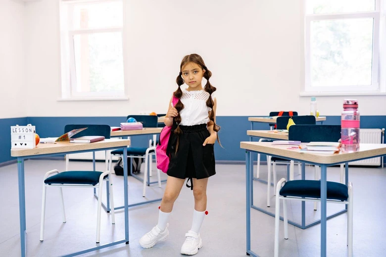 Anak remaja tersenyum memakai tas ransel di hari pertama sebagai bagian dari adaptasi anak masuk smp.