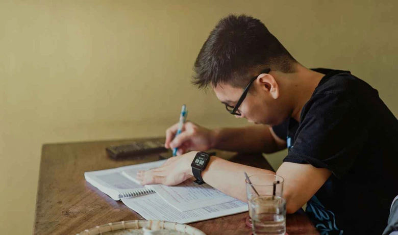Siswa sedang fokus belajar di meja sebagai ilustrasi cara daftar les privat semester baru.