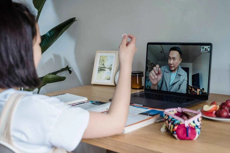 Siswa fokus belajar melalui laptop dibantu oleh guru privat pendamping belajar tahun ajaran baru secara virtual.