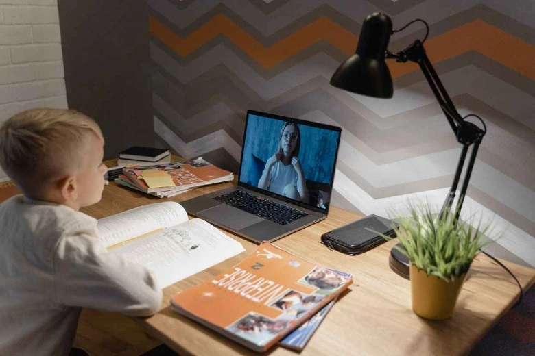 Siswa berinteraksi dengan tutor melalui video call di laptop saat sesi les privat online awal tahun ajaran.